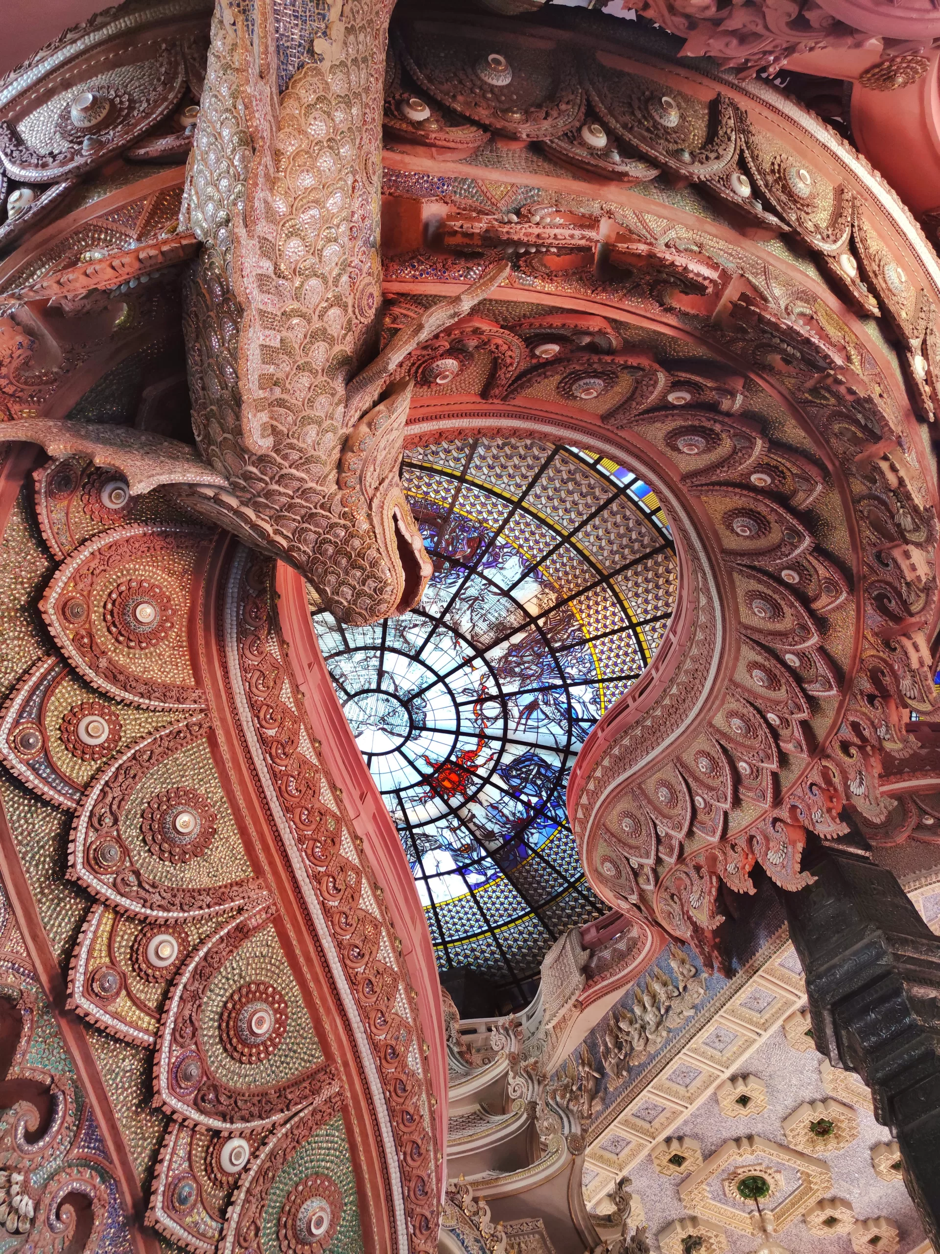 Detailed architecture of the Erawan Museum with pink walls and mocaic glass