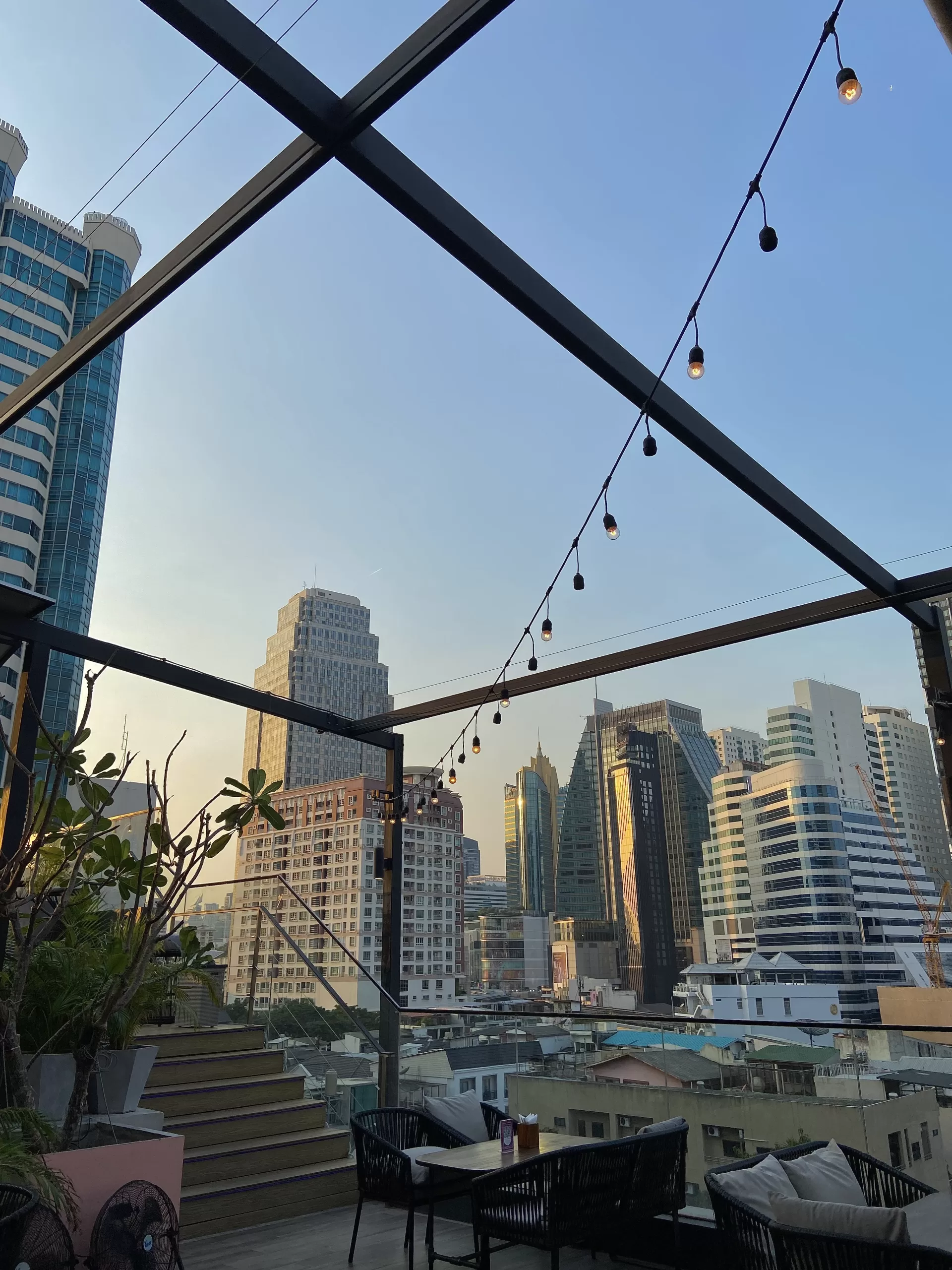 Rooftop Bar in Bangkok, Thailand during sunset with fairy lights and skyscrapers